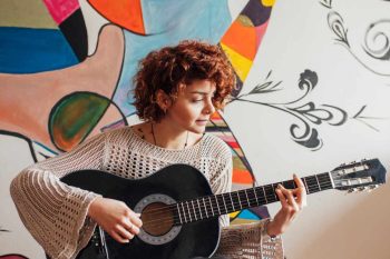 Young woman laying guitar