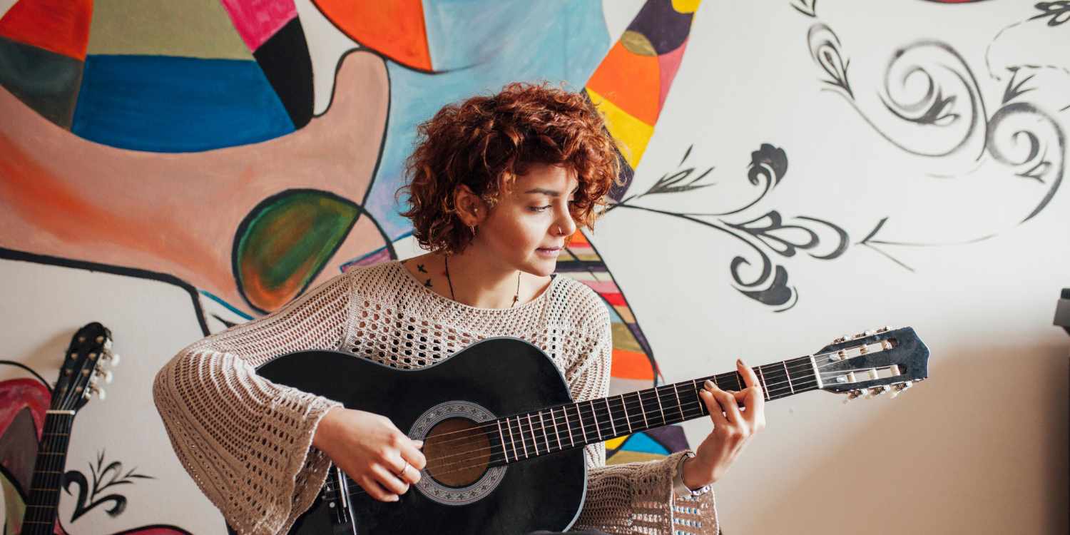 Young woman laying guitar