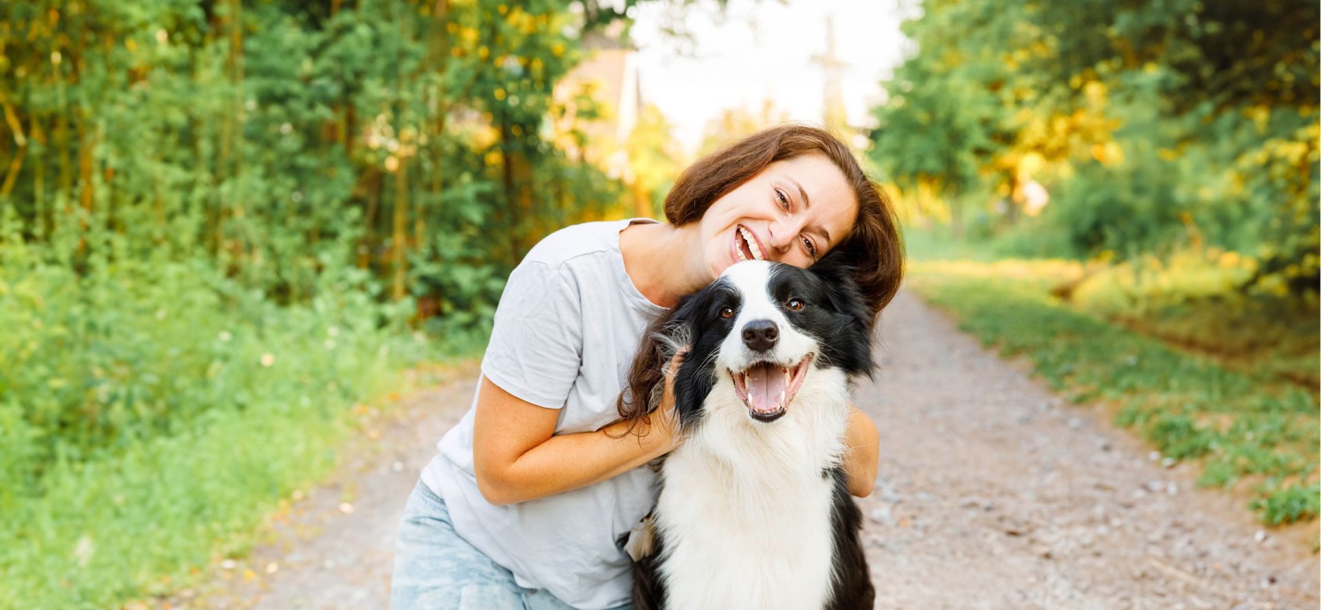 smiling woman hugging her dog in the part