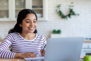 adult woman sitting with laptop during online class