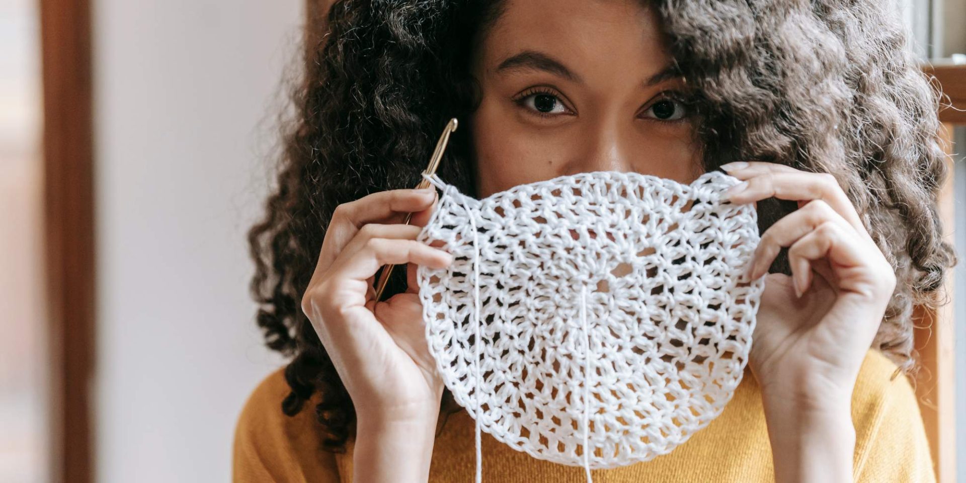 Woman smiling and doing crochet
