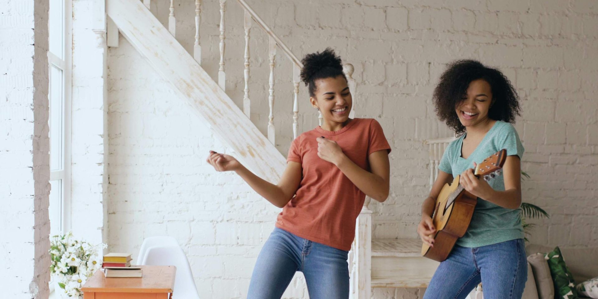 two young woman dancing and playing guitar