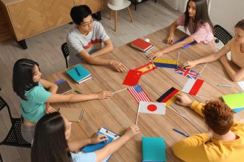 people sitting around the table with different countries flags