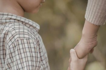child and adult holding hands