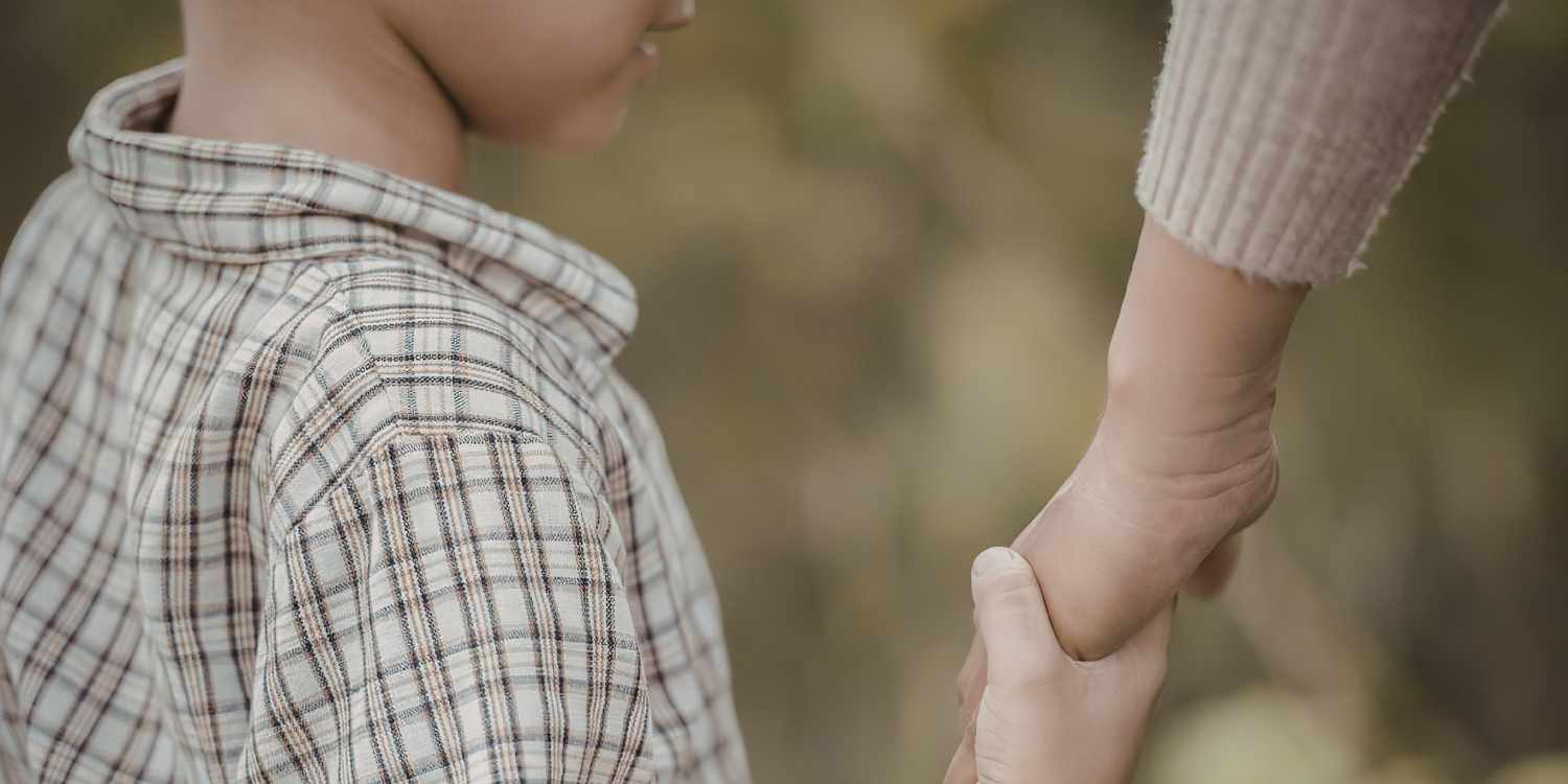 child and adult holding hands