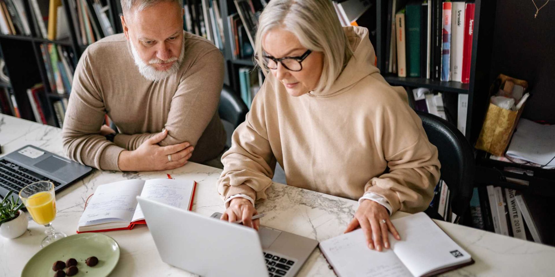 senior man and woman sitting with laptop