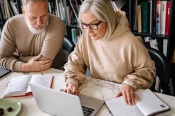 senior man and woman sitting with laptop