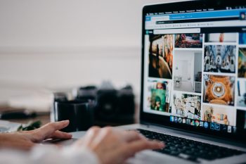 Small business owner creating social media content on a laptop using Canva and video editing tools.