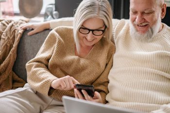 senior man and woman using smartphone to make a call